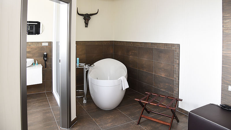 Das braun geflieste Badezimmer passt sich den rustikaleren Raumkonzept eines Zimmers des Hotels Aragon in Tangermünde an